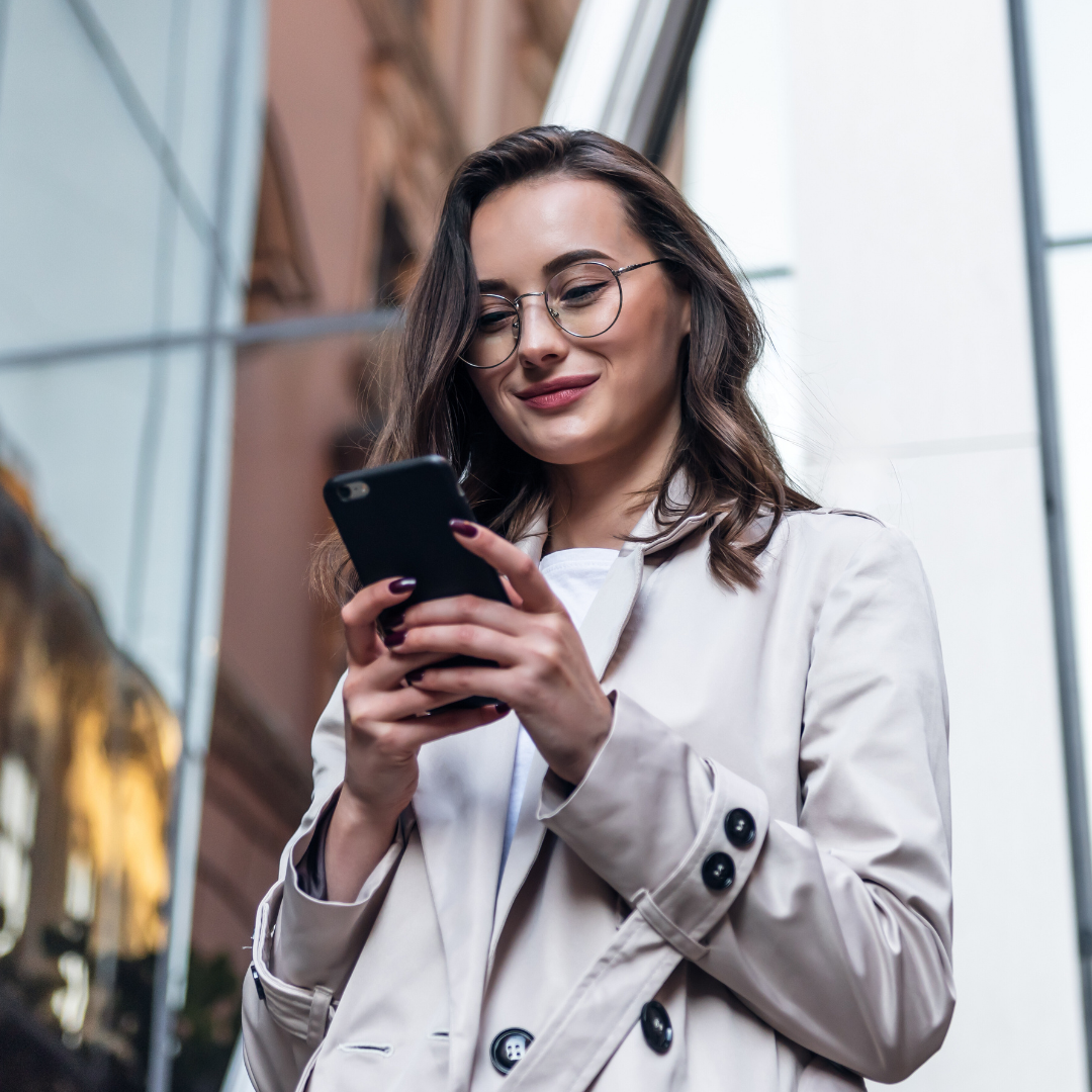 A woman on the street going through her emails